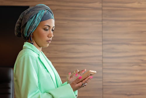 Free Woman Wearing Hijab Using Smartphone Stock Photo