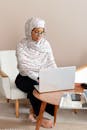 Woman in White and Pink Hijab Sitting on White Chair