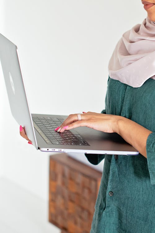 Hands with Pink Manicured Nails Typing on a Laptop 