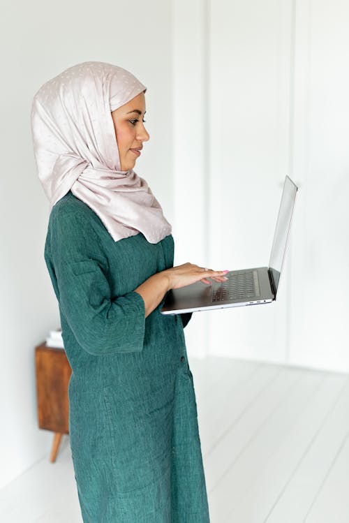 Woman Standing while Using Her Laptop