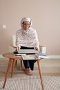Woman in White Hijab Sitting on Brown Wooden Table