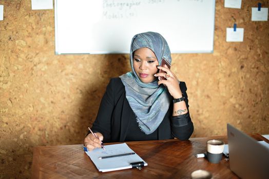 Woman in Gray Hijab and Black Long Sleeve Shirt Sitting on Chair