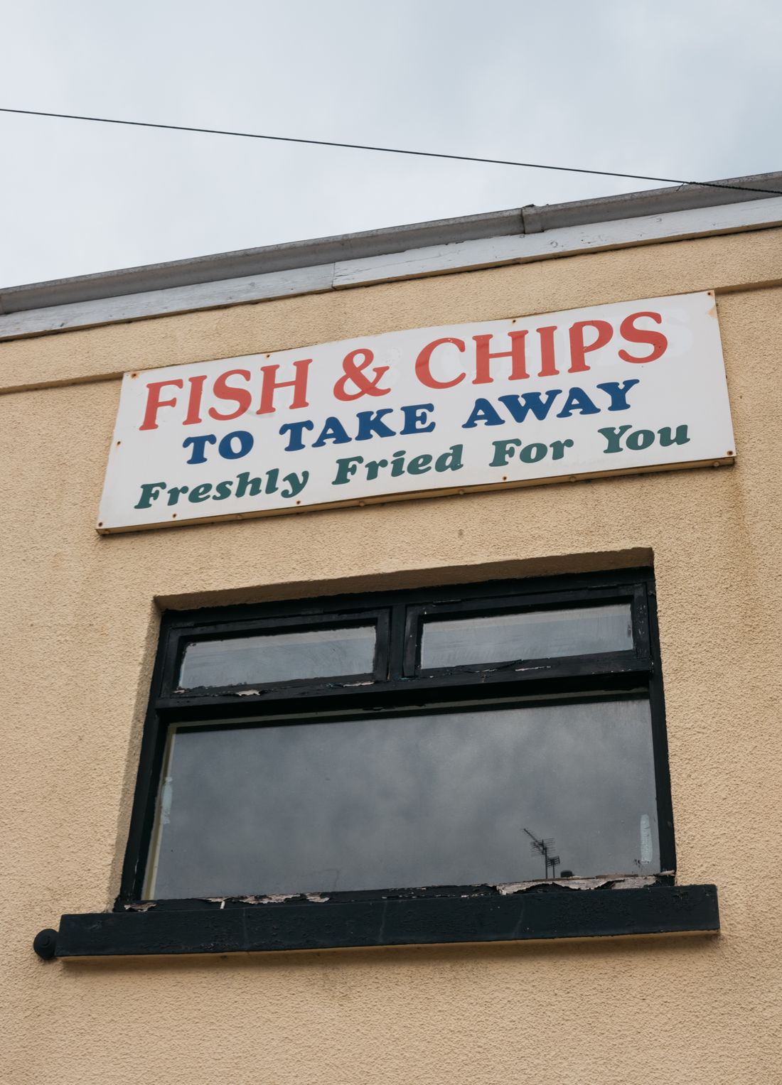 The front of a fish and chip shop with its takeaway sign