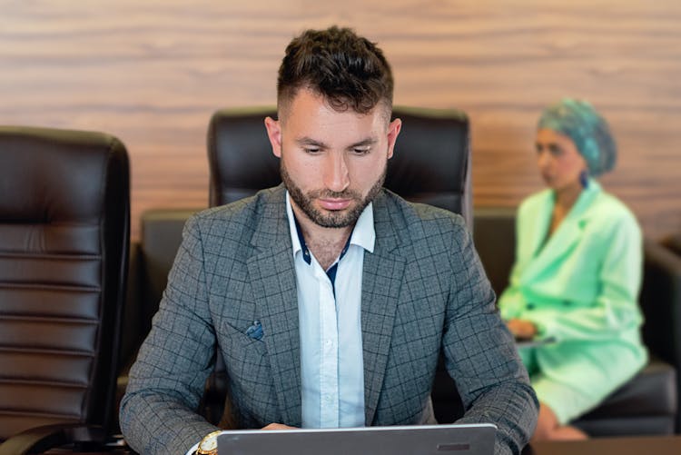 A Bearded Man Wearing A Gray Plaid Suit