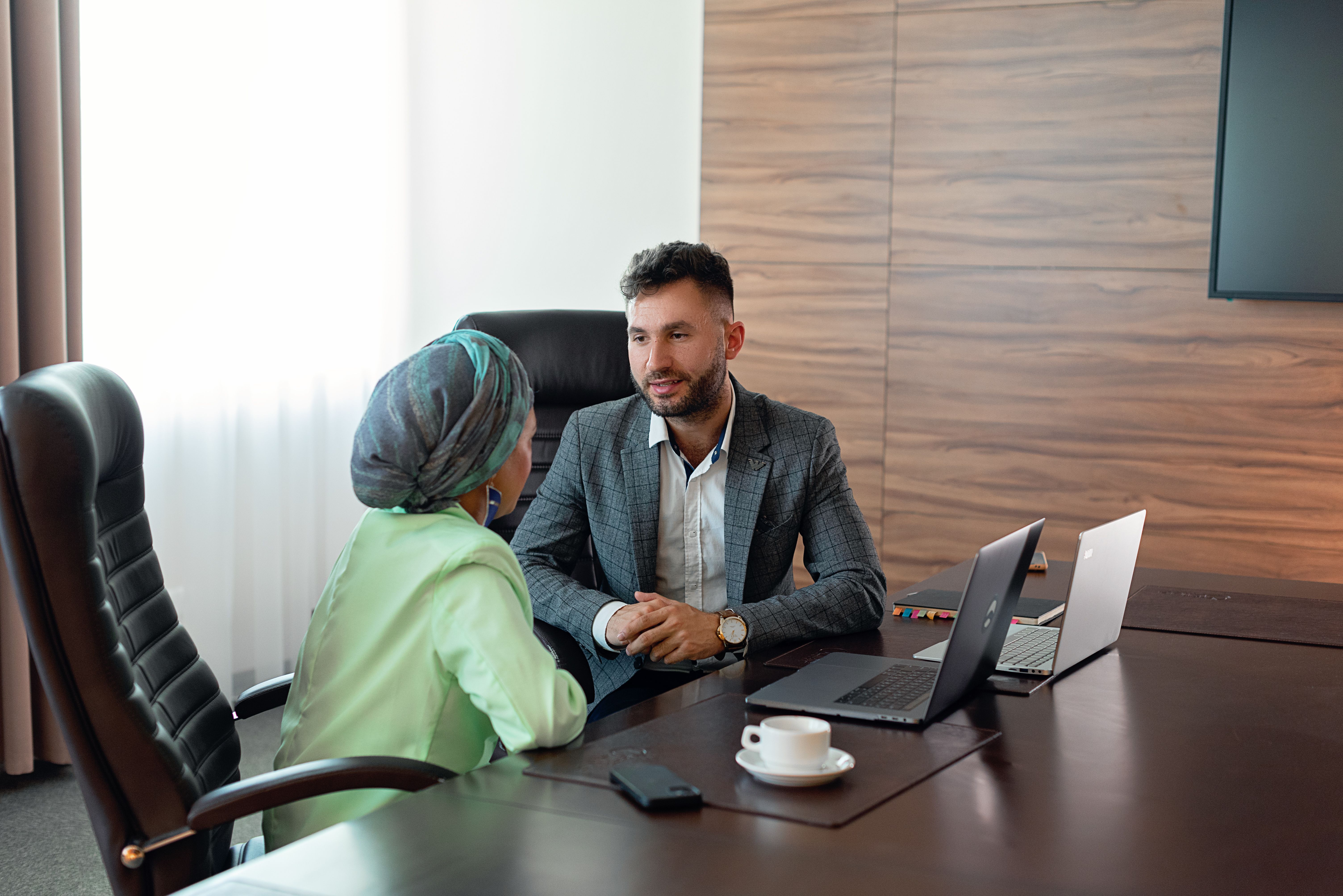 Two business colleagues discuss strategies during an office meeting, fostering teamwork.