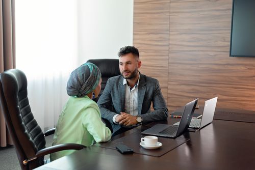 Free Two business colleagues discuss strategies during an office meeting, fostering teamwork. Stock Photo