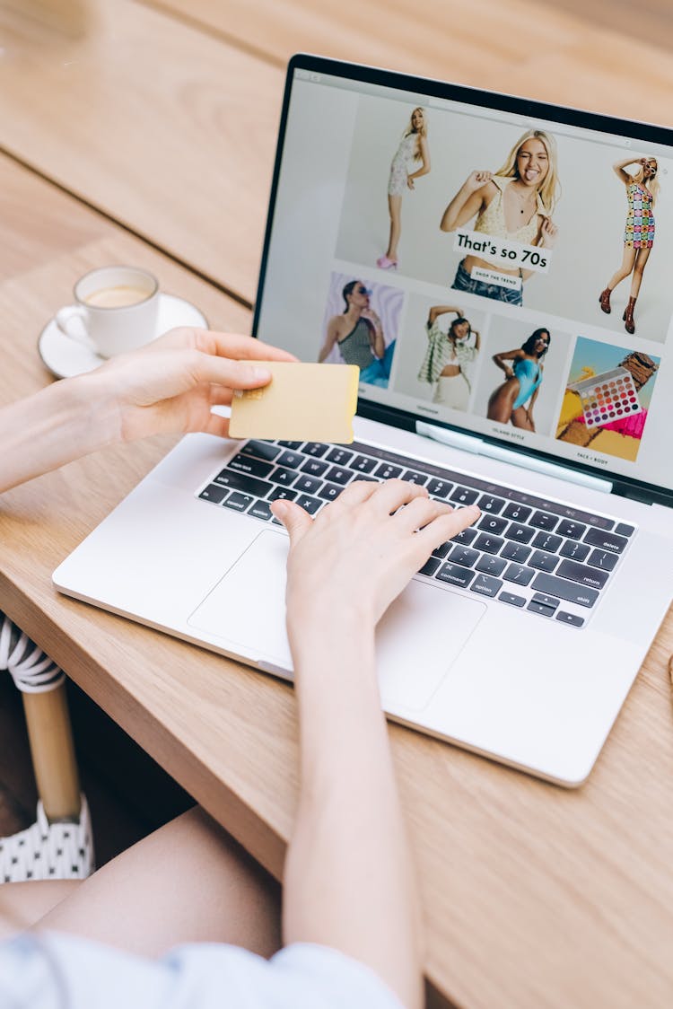 Person Using A Laptop While Holding A Credit Card