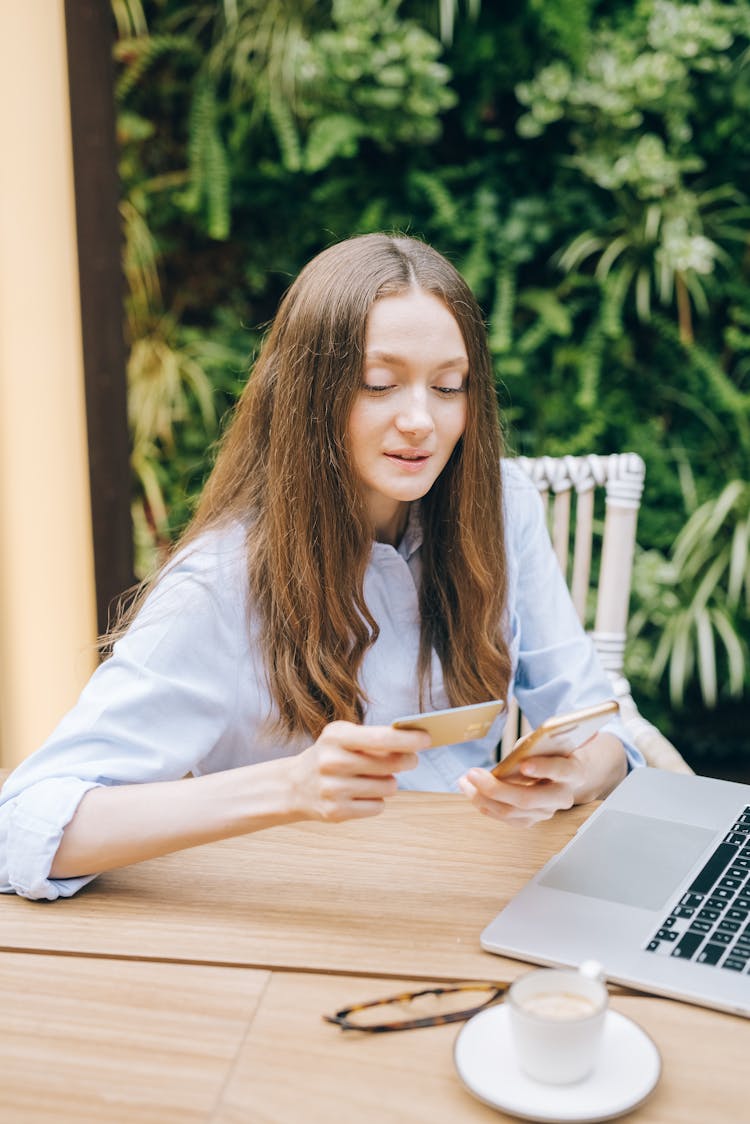 Woman In Long Sleeves Holding A Card And Smartphone 