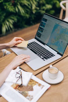A person using a laptop and credit card, surrounded by a magazine and coffee cup.