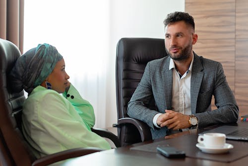 A Man and Woman Sitting on Office Chairs