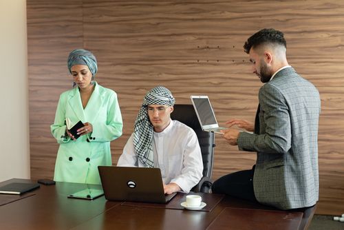 Free Middle Eastern business professionals engaged in teamwork within an office setting. Stock Photo