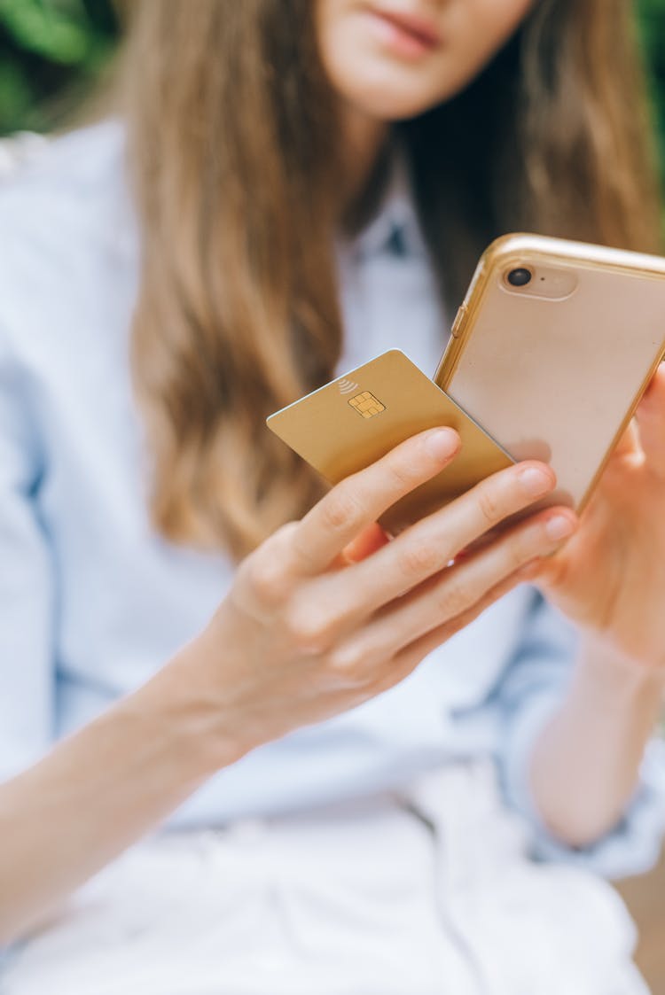 Person Holding A Smartphone And A Credit Card