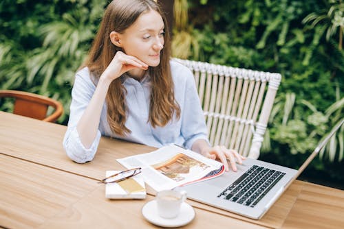 Free Woman Sitting While Using a Laptop Stock Photo