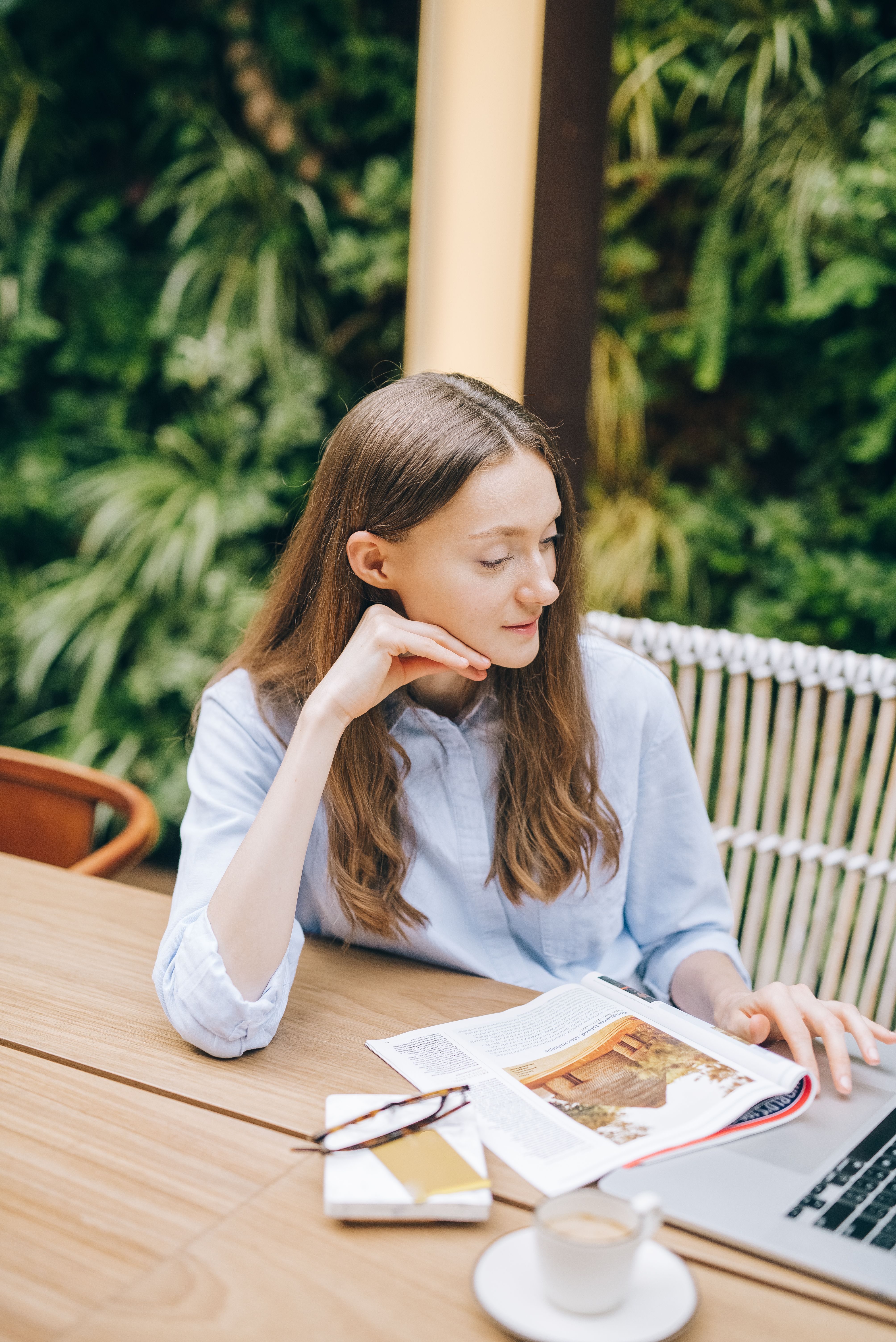 Woman Sitting and Using a Laptop on a Table · Free Stock Photo