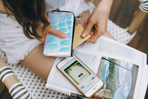 Person Holding a Coin Purse and Debit Card