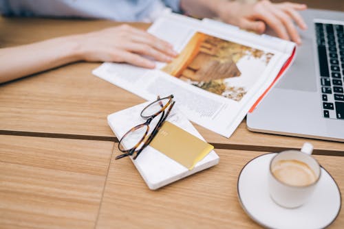 Eyeglasses and Card on Top of a Book 