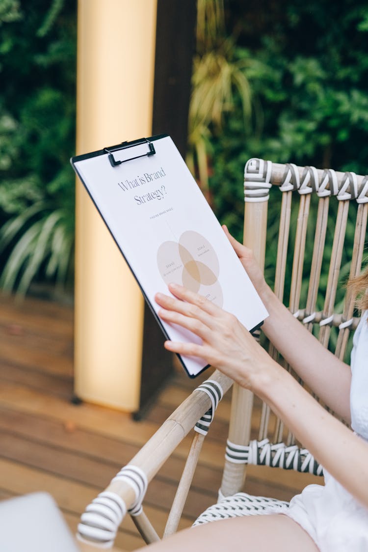 Person Holding Clipboard With White Paper 