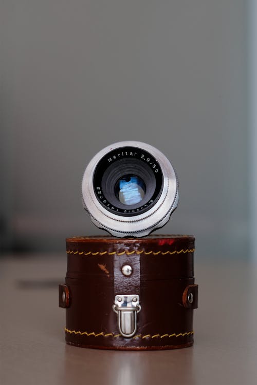 A Camera Lens on a Brown Leather Container