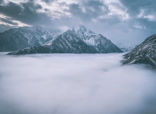 Snowcapped Mountain Peaks above Clouds