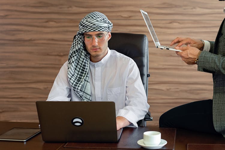 A Man Using A Laptop In The Office