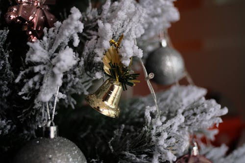 Free A Gold Bell Hanging on Frosted Christmas Tree Stock Photo