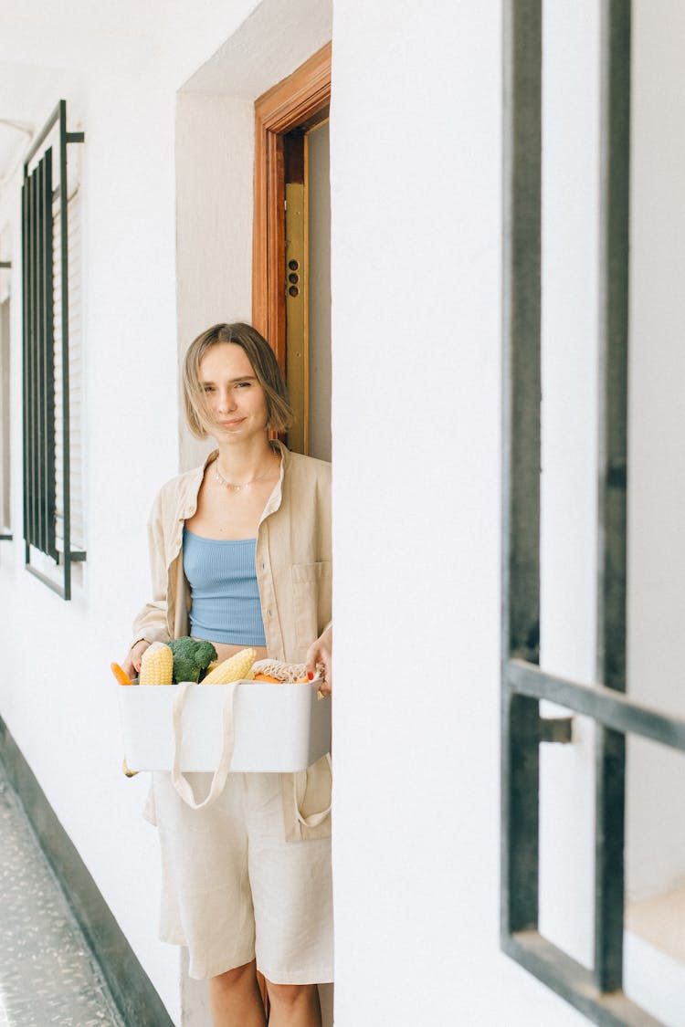 A Woman Holding A Basket Of Food