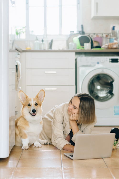 Free A Woman Looking at Her Dog while Sitting on the Floor Stock Photo