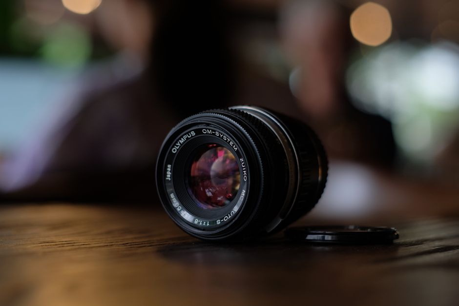 Detalhe dos elementos ópticos de objetiva 35mm com bokeh em segundo plano demonstrando separação de planos em abertura f/1.2