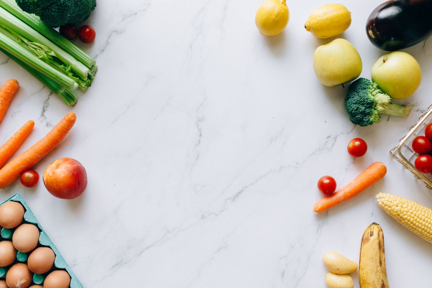 Fresh fruit and vegetables laid out on a marble counter — photo by Nataliya Vaitkevich on Pexels