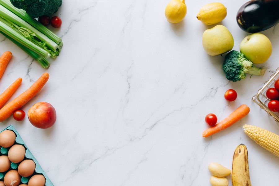 Flat lay of fresh fruit and vegetables on a marble surface — photo by Nataliya Vaitkevich on Pexels