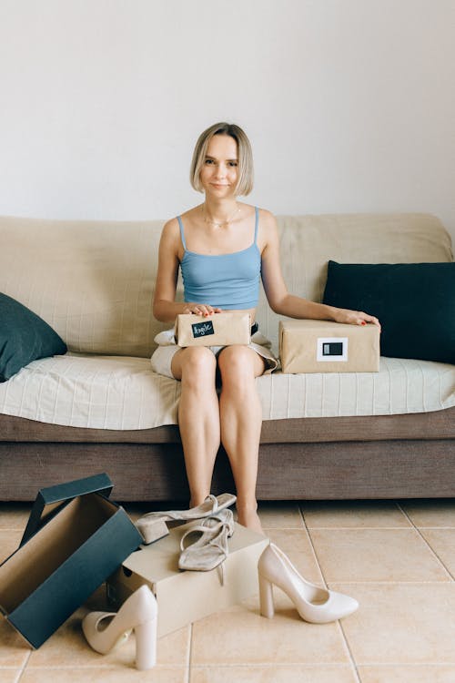Free Woman in Blue Tank Top Sitting on Couch Stock Photo