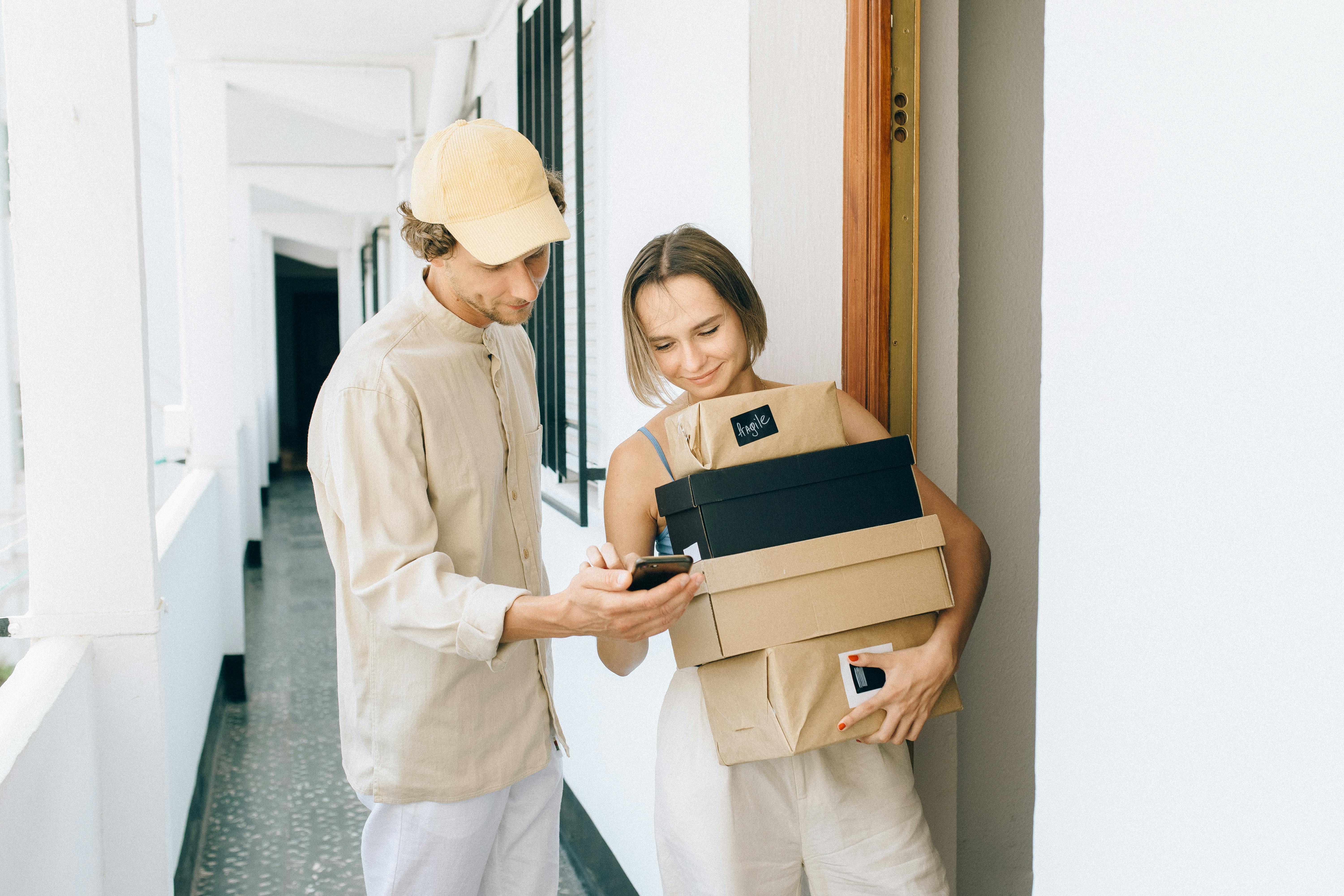 a woman receiving her parcels while standing beside the delivery man