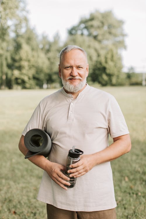 Man Holding Water Bottle and Yoga Mat