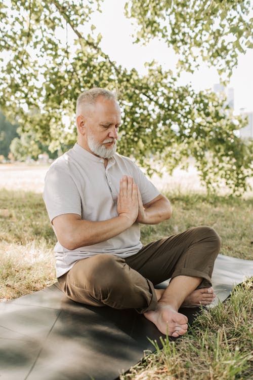 An Elderly Man Meditating with His Hands Together