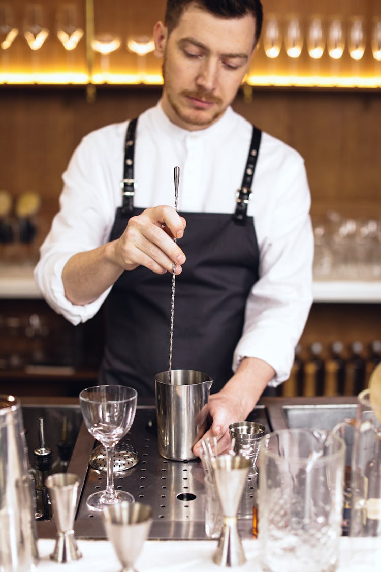 A Bartender Mixing Cocktail Using A Swizzle Stick