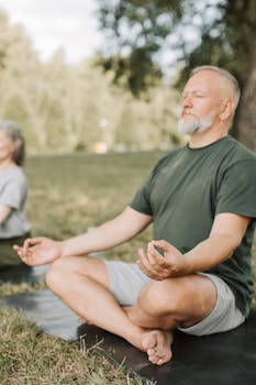 Senior man practicing yoga outdoors on a sunny day, promoting wellness and tranquility.