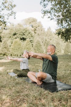 Elderly couple performing yoga stretches on mats in a serene park setting.