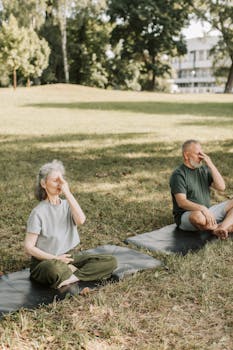 Elderly couple practicing yoga and meditation outdoors for a healthy lifestyle.