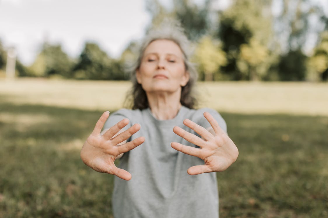 Woman deep breathing performing tai chi for stress relief and calming the nervous system