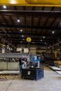 Man in White T-shirt Standing Near Black and Yellow Metal Machine
