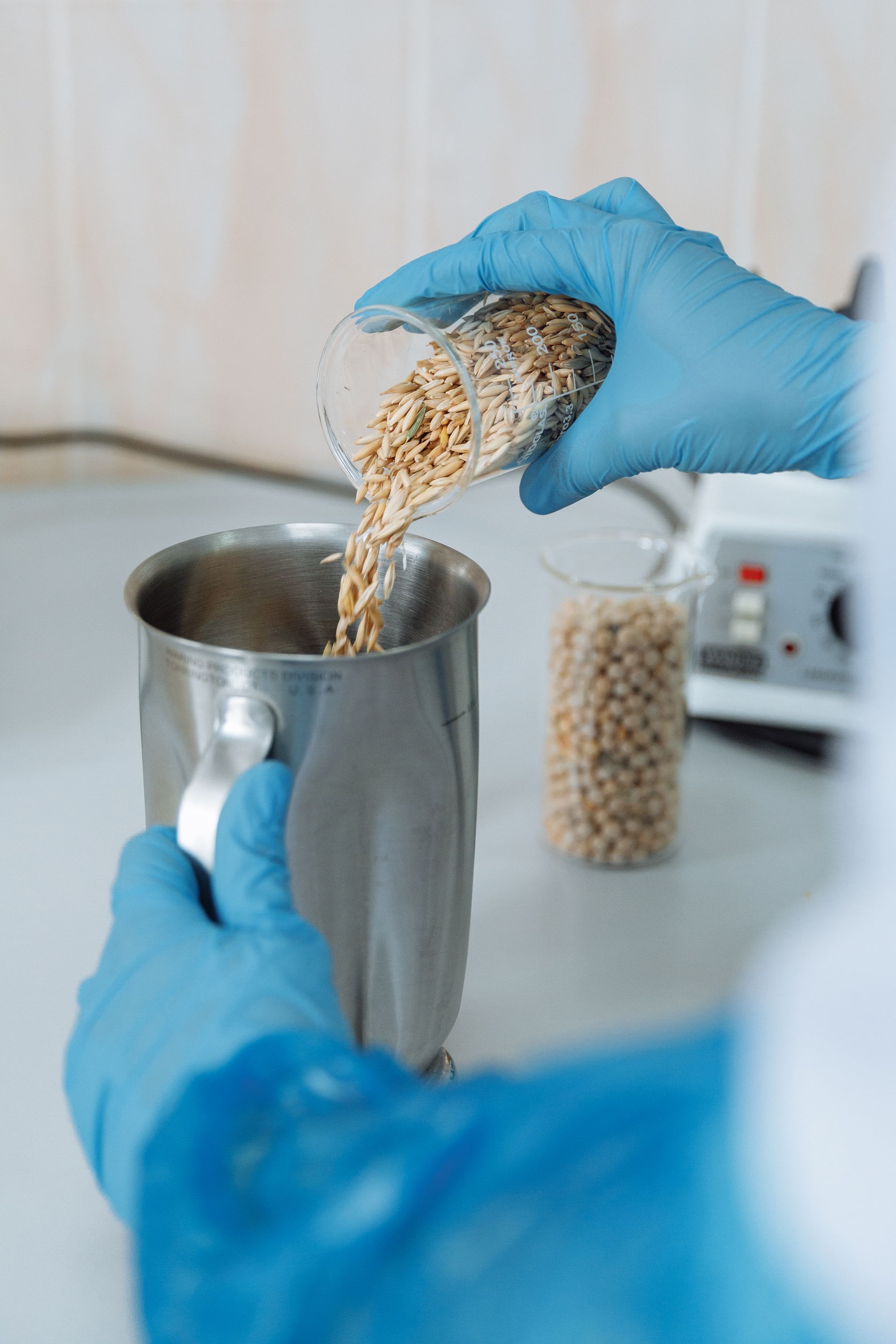 Food scientist evaluating an ingredient sample in a stainless-steel vessel.