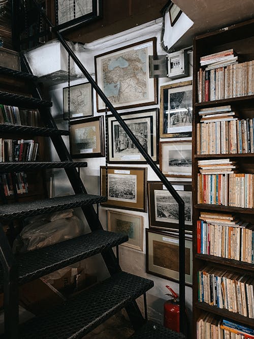 Black Wooden Shelf With Books beside Black Metal Stairs