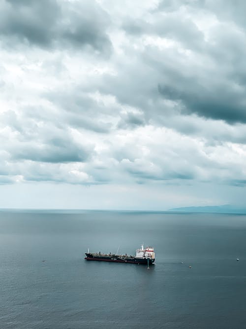 Photo of Boat On Sea Under Cloudy Sky