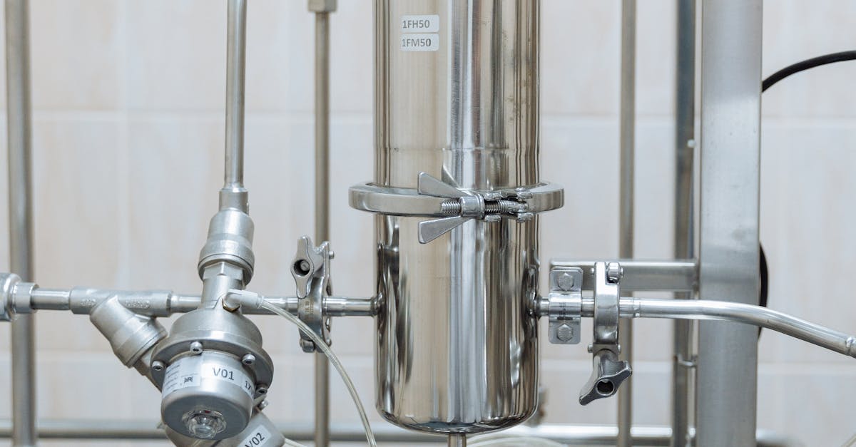 Close-up of a stainless steel industrial plumbing system with pressure gauges and steel pipes.