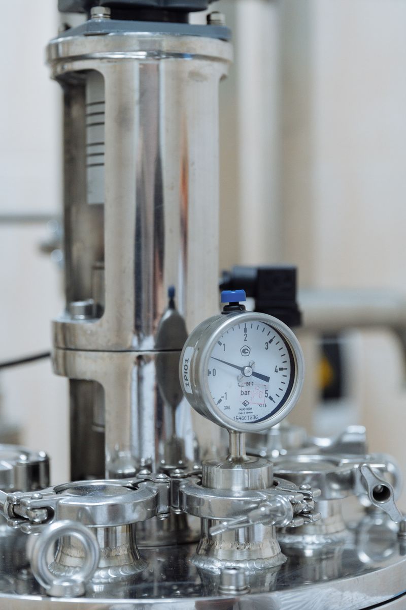 Detailed view of a stainless steel pressure gauge in a laboratory setting