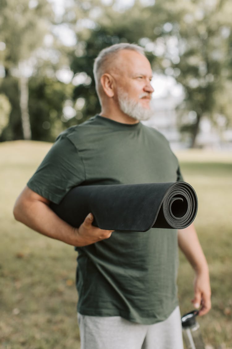 A Man Carrying A Yoga Mat