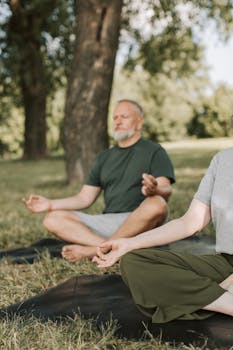Serene senior couple meditating in a park, embracing a healthy lifestyle and wellness.