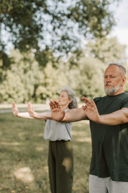 Elderly Man and a Woman Doing Yoga