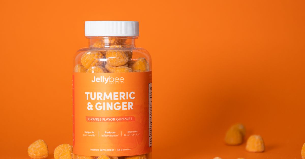 Bright product shot of turmeric and ginger gummies in a plastic bottle against an orange background. - Evidence evidence guide for turmeric joint pain randomized trial
