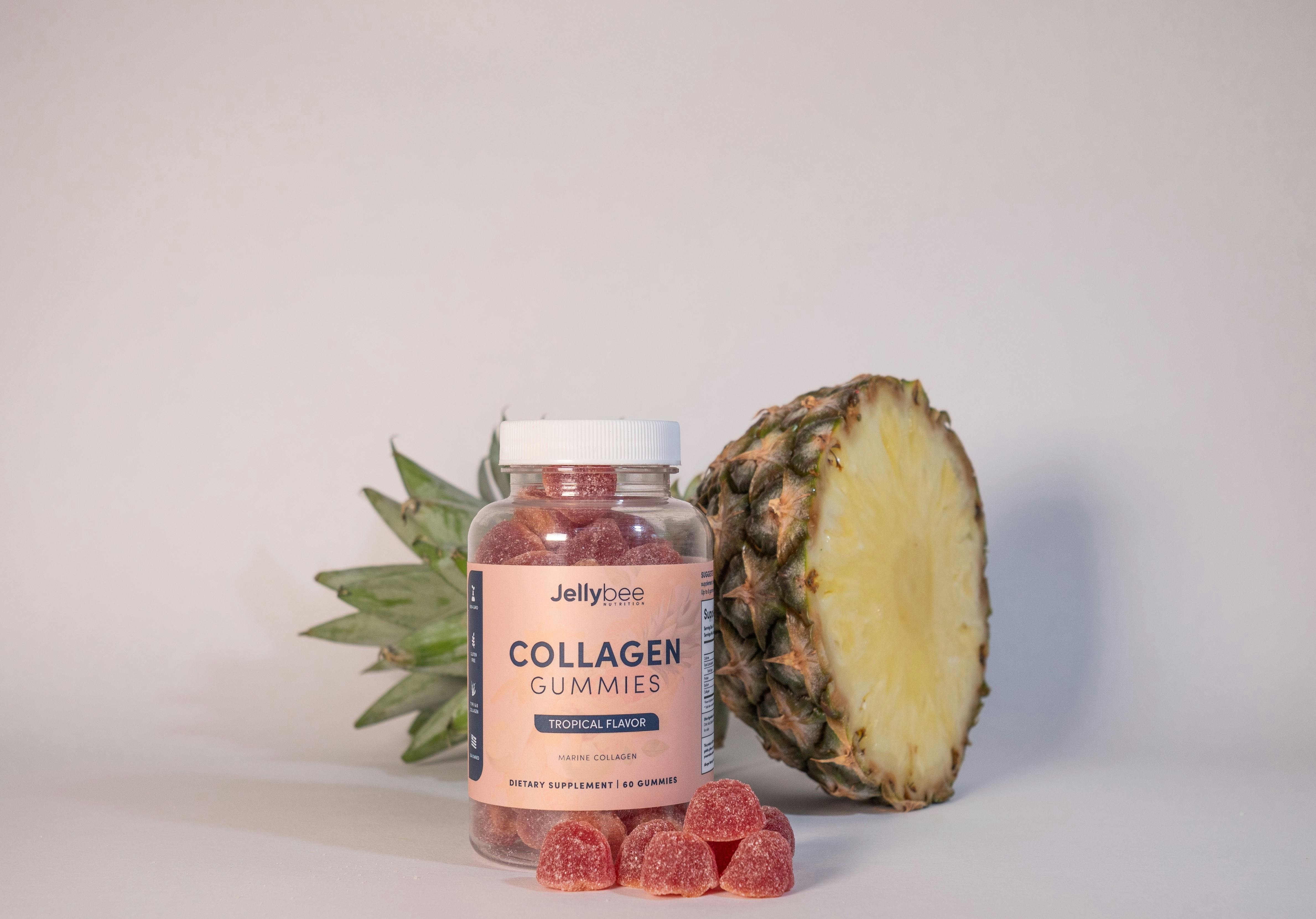 collagen gummies in plastic bottle beside a sliced pineapple